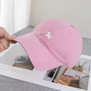 Nahaufnahme der rosa Baumwoll-Basecap mit weißer Welpenstickerei und gebogenem Schirm