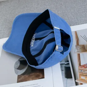 Detail view of cotton baseball cap showing internal embroidery and metal adjustment buckle