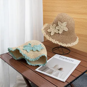 Detail of woven straw hat featuring handmade starfish decor and delicate lace trim