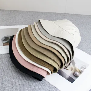 Détail de bobs en coton avec bords effilochés et plusieurs options de couleurs