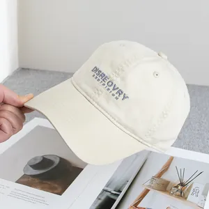Detail of beige cotton baseball cap with embroidered grey DISREOVRY text and curved brim