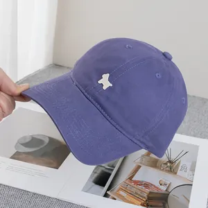 Nahaufnahme der violetten Baumwoll-Basecap mit detaillierter weißer Tierstickerei