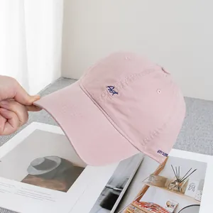 Detail showing the pink cotton baseball cap with blue ART embroidery and EST 1993 side text