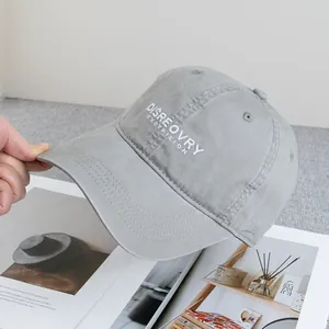 Close-up of light gray washed cotton baseball cap with white 3D letter embroidery