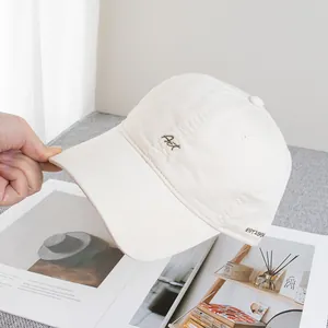 Detail of Art embroidery on cream cotton baseball cap with EST 1994 stitching