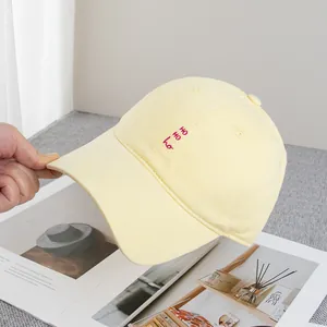 Detail van een lichtgele baseballpet met rood Koreaans borduursel erop