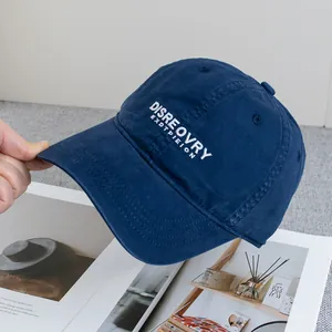 Close-up of white letter embroidery on a navy cotton twill baseball cap with curved brim