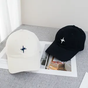 Détail de la broderie étoile sur casquettes de baseball en coton noir et crème