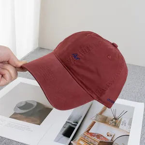 Detailed close-up of wine red canvas baseball cap featuring blue Art embroidery