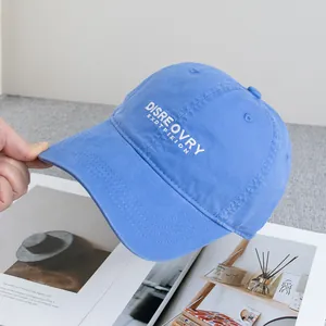 Close-up of light blue washed cotton baseball cap with white DISREOVRY embroidery