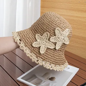 Detail of hand-woven straw hat featuring white crochet lace edge and starfish accents