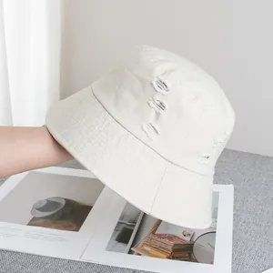 Vue détaillée du chapeau bob en coton ivoire avec des bords déchirés au style vintage