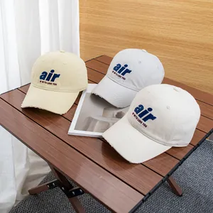 Close-up of vintage baseball caps with air embroidery and distressed brims on a wooden table