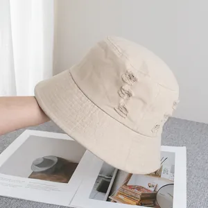 Vue détaillée des bords effilochés et du style usé sur un chapeau bob en coton