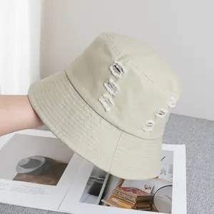 Détails d'un chapeau bob en coton beige avec effet usé et bords effilochés stylés