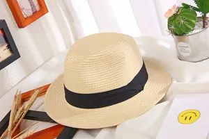 Detail of beige straw sun hat with black ribbon, jazz style flat top weave texture