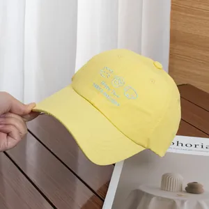 Détail de la casquette jaune avec broderie d'animaux mignons et texte Happy Time brodé
