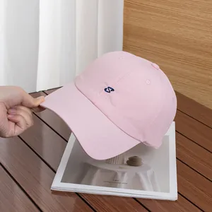 Dettaglio cappellino rosa con ricamo S blu scuro e fori traspiranti per l'aria fresca