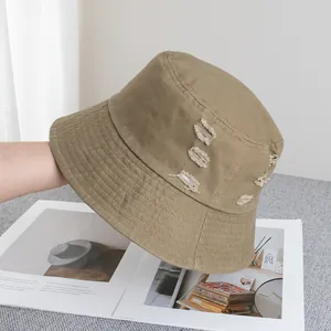 Gros plan détaillé du chapeau bob en coton kaki avec bords effilochés et coutures