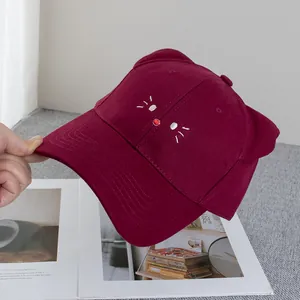 Dettaglio del ricamo a orecchie di gatto su cappellino da baseball in cotone bordeaux