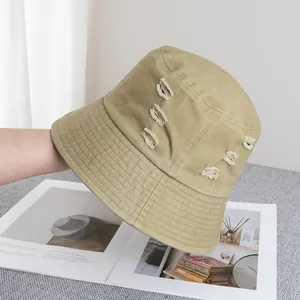 Détails des trous usés et du tissu en coton sur ce chapeau de pêcheur à large bord