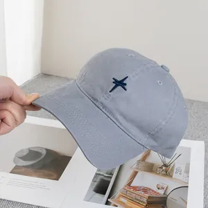 Détail de la broderie étoile croisée sur une casquette de baseball en coton bleu clair