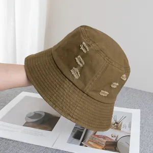 Détail du bob en coton kaki avec finitions trouées et coutures renforcées sur le bord