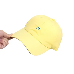 Berretto da baseball giallo ad asciugatura rapida con logo S ricamato blu tenuto in mano