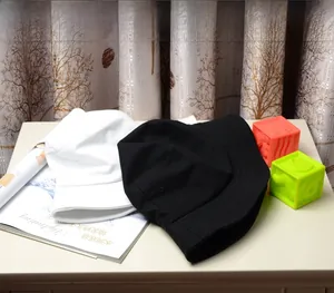 Détails des bobs en coton noir et blanc pour la protection solaire sur un bureau