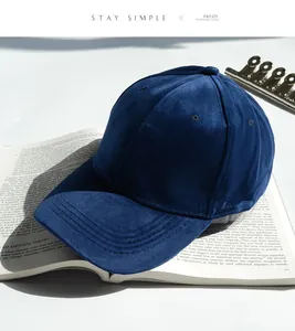 Vue détaillée d'une casquette en velours bleu marine montrant sa texture sur un livre