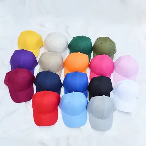 Cappellini da baseball classici in cotone multicolore su sfondo di tessuto bianco