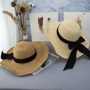 Wide brim straw sun hats with black ribbon bow in beige and natural wood colors