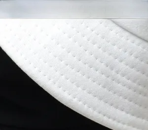 Gros plan d'un bob en toile blanche montrant les coutures parallèles et la texture du tissu