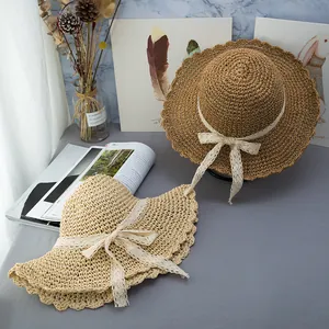 Cappello di paglia intrecciato a mano con fiocco di pizzo bianco e tesa ondulata