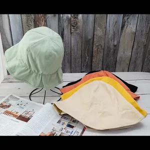 Reversible cotton bucket hat with scalloped edge in various colors on wooden surface