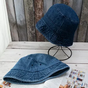 Detailed view of washed denim bucket hat with metal eyelets and reinforced brim stitching