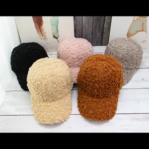 Plush lamb wool baseball caps in five colors on a white wooden background for winter warmth