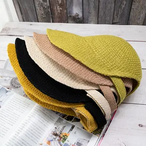 Macro shot of knitted equestrian hats in multiple colors stacked on a magazine and wood