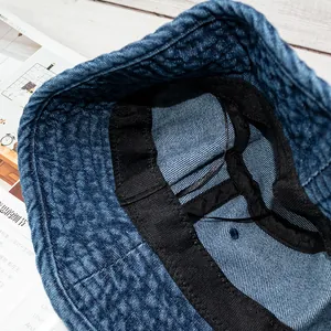 Detail view of denim bucket hat showing inner black sweatband and adjustable drawstring
