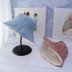 Close-up of double-sided cotton bucket hat in light blue and pink with stitching detail