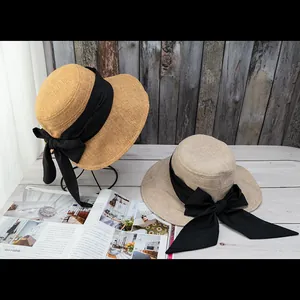 Women summer sun hat with large black bow in ginger yellow and beige straw material