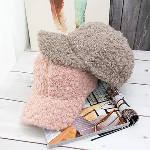 Close-up of thick plush teddy fleece baseball caps in pink and brown on a magazine