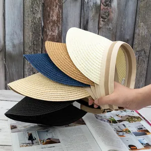 Close-up of woven straw sun visors in various colors showing texture and stripe detail