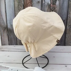 Detailed close-up of handmade cloth label on cream cotton bucket sun hat for women