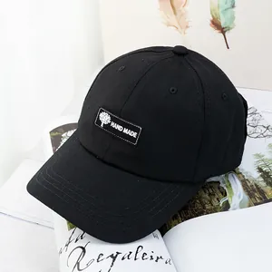 Détail d'une casquette noire avec écusson arbre sur fond de magazine lifestyle