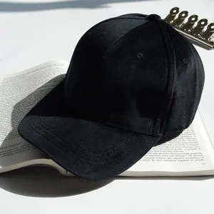 Casquette de baseball classique en velours noir au design minimaliste sur fond de livre