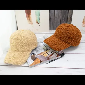 Detailed view of warm lamb wool baseball caps in beige and brown colors on wooden background