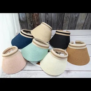 Seven colors of woven straw sun visors with striped bands displayed on wooden boards