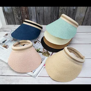 Detailed overhead view of multiple straw sun visors in various colors on a wooden surface