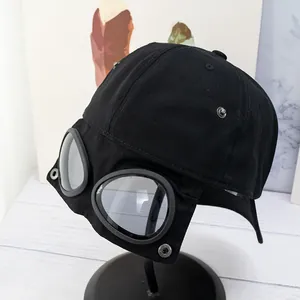 Détail d'une casquette aviateur noire avec lunettes intégrées et rivets métalliques